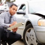 insurance adjuster inspecting damages to a car involved in an accident for blog post entitled How do I recover damages from an accident