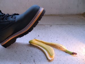 If you are injured on someone else’s property, the landowner may be liable for your injuries. Pictured: Person wearing boot is about to step on banana peel.